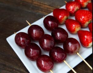 Close-up of glistening vegan Tanghulu with a crunchy sugar coating, showcasing the vibrant colours of fresh fruit inside.