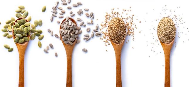 Hemp seeds scattered on a wooden table, a great source of zinc and omega-3s